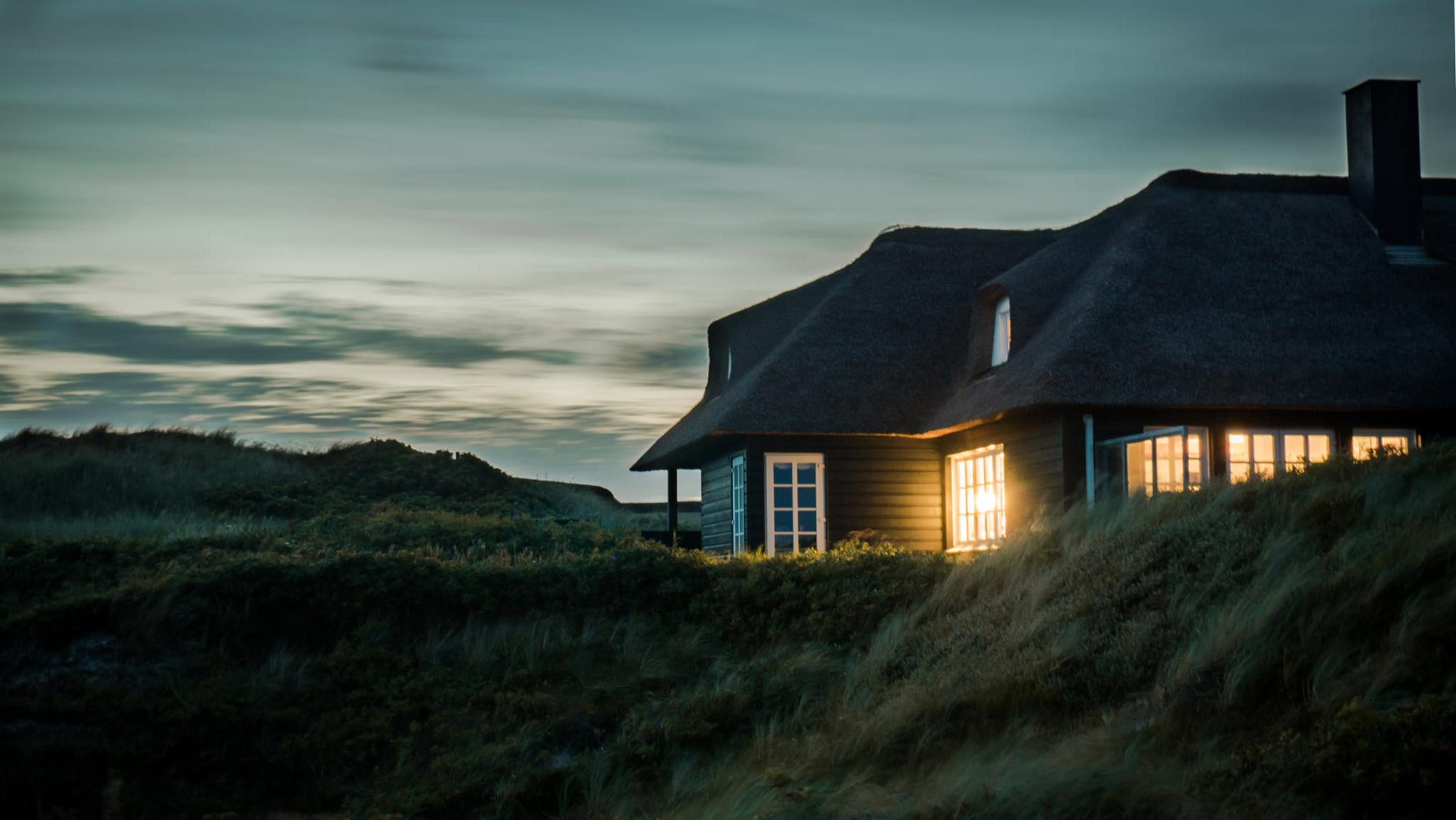House at night with light shining.