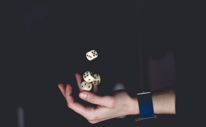 Man tossing dice, representing risk.