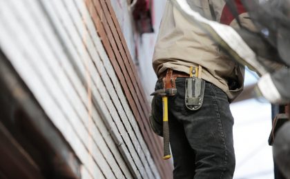 Worker repairing wall after homeowners claim.