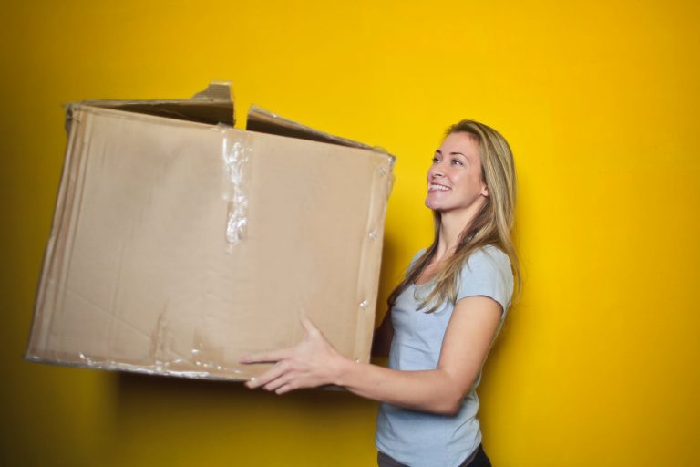 Woman holding moving box.