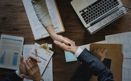 Two people shaking hands over a business deal.