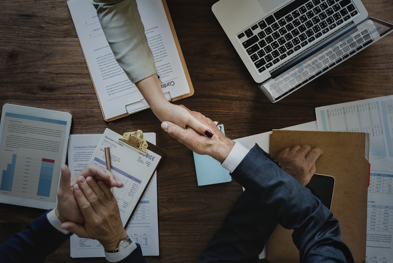 Two people shaking hands over a business deal.