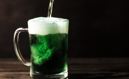 Person pouring green beer.