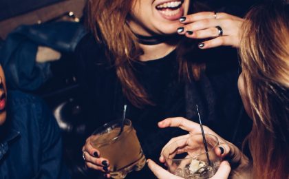 Two women laughing at a bar.