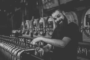 Bartender smiling while pouring beer.