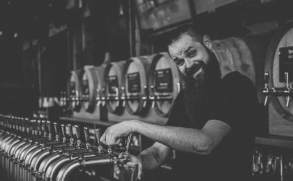 Bartender smiling while pouring beer.