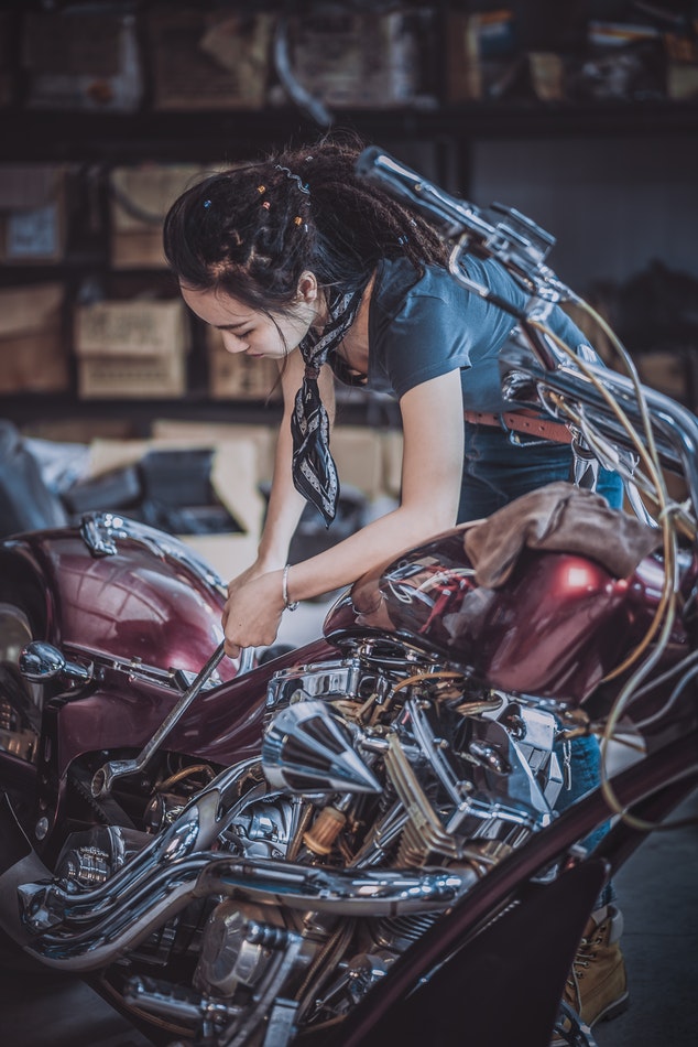 Woman working on a motorcycle.