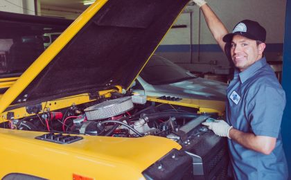 Mechanic standing in front of car.