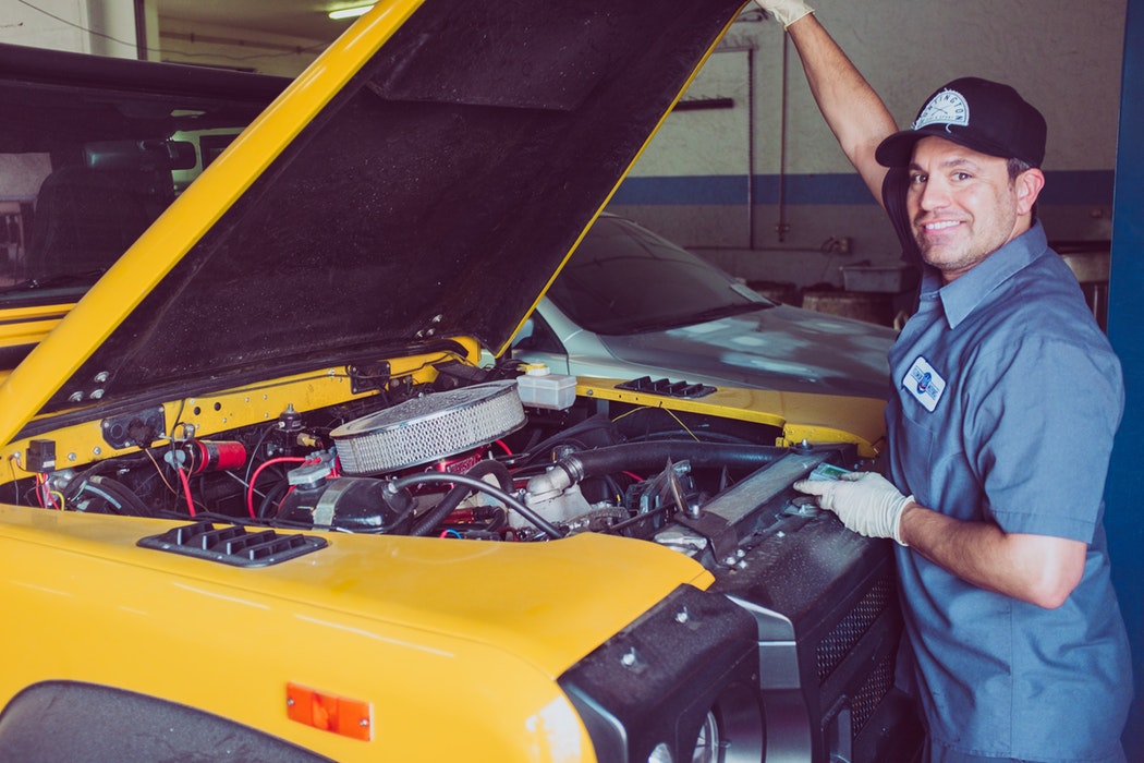 Mechanic standing in front of car.