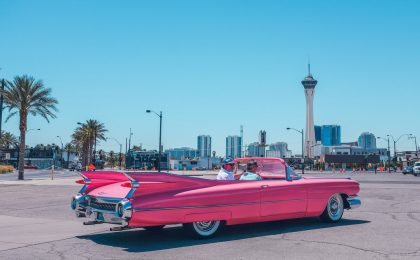 Man driving pink convertible car while business is paid for by business income coverage.