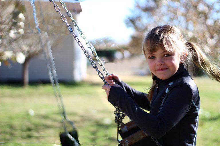 Little girl on swing set.