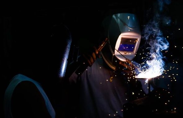 Man welding wearing garage safety visor.