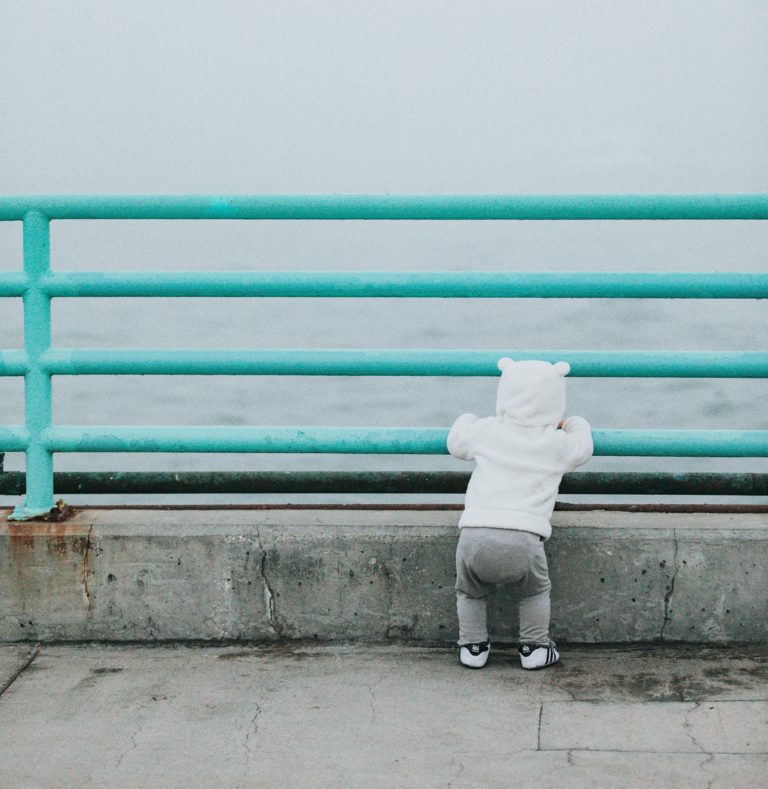 Baby thinking about communication while looking at the water.
