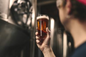 Man holding beer in brewery