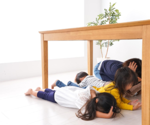 People covering their heads during an earthquake.