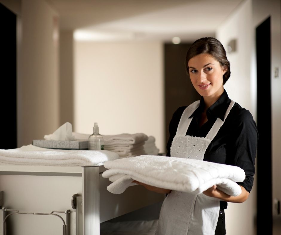 Woman with towel cleaning in a hotel.