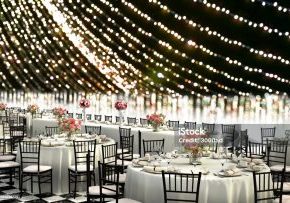 3D Illustration of a wedding reception venue decorated in white with ten seat round tables and a head table on a bokeh background